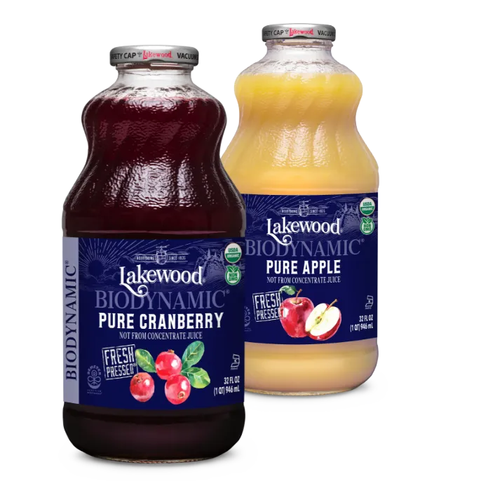 Two bottles of Lakewood juice, one cranberry and one apple, on a white background.