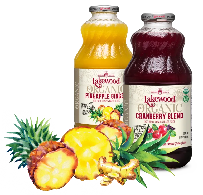 Two bottles of Lakewood Organic juice, one pineapple ginger and one cranberry blend, with fresh pineapple and ginger on a white background.